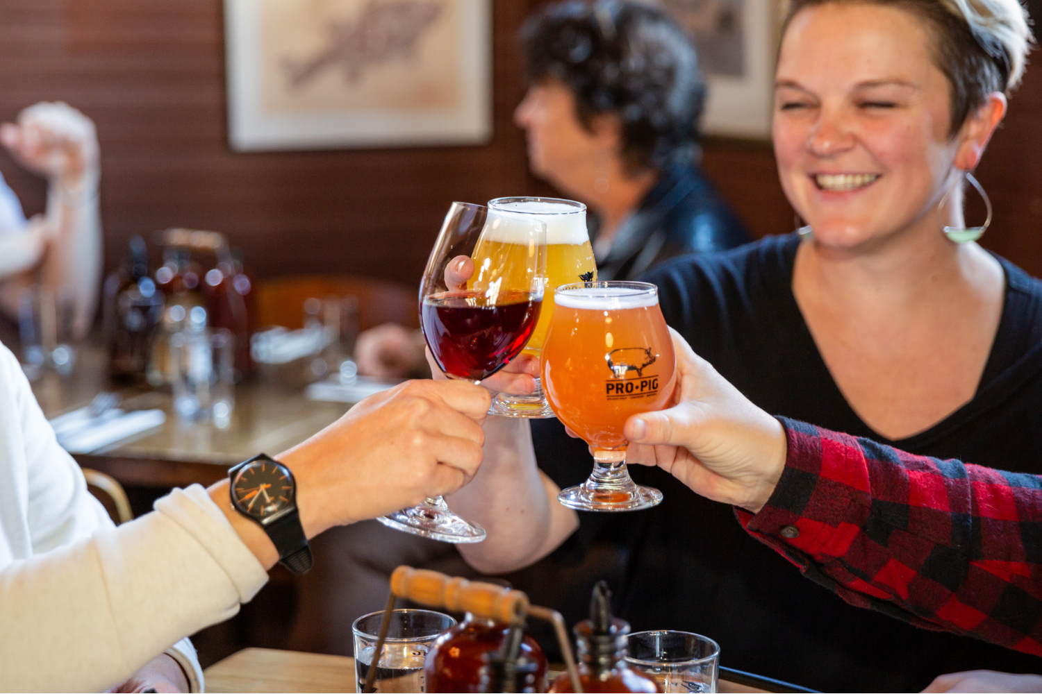 Individuals raising a toast with beer