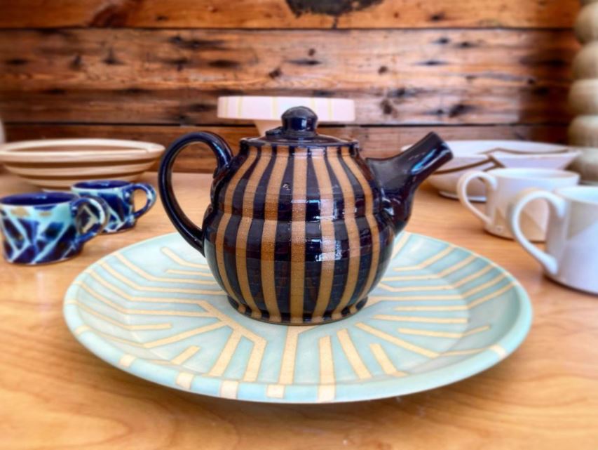 A display of striped pottery, including a teapot and platter