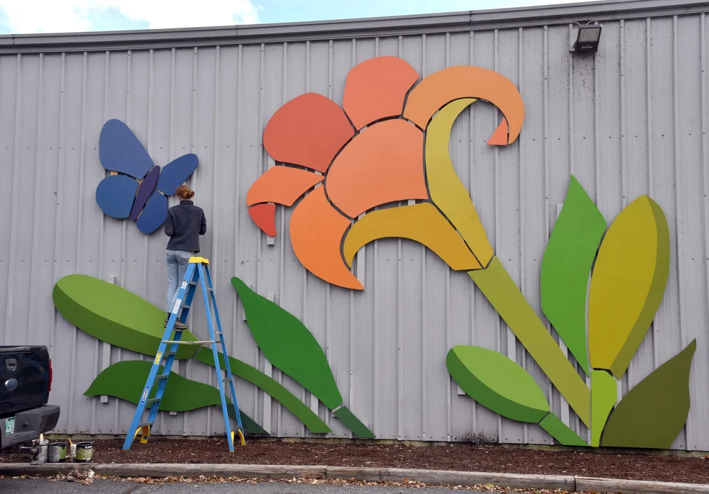 Artist Mary Lacy working on the Market Blooms installation at Waterbury's Village Market